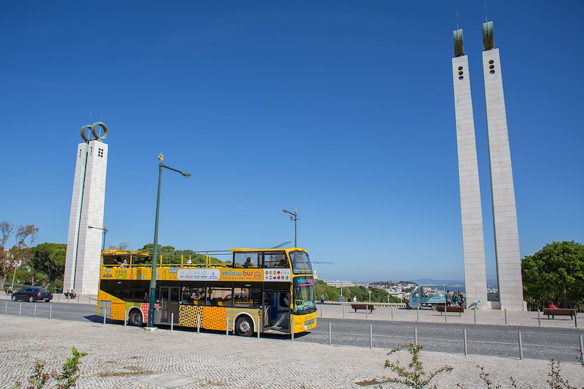 Hop-on hop-off bus driving along the streets of Lisbon during the day