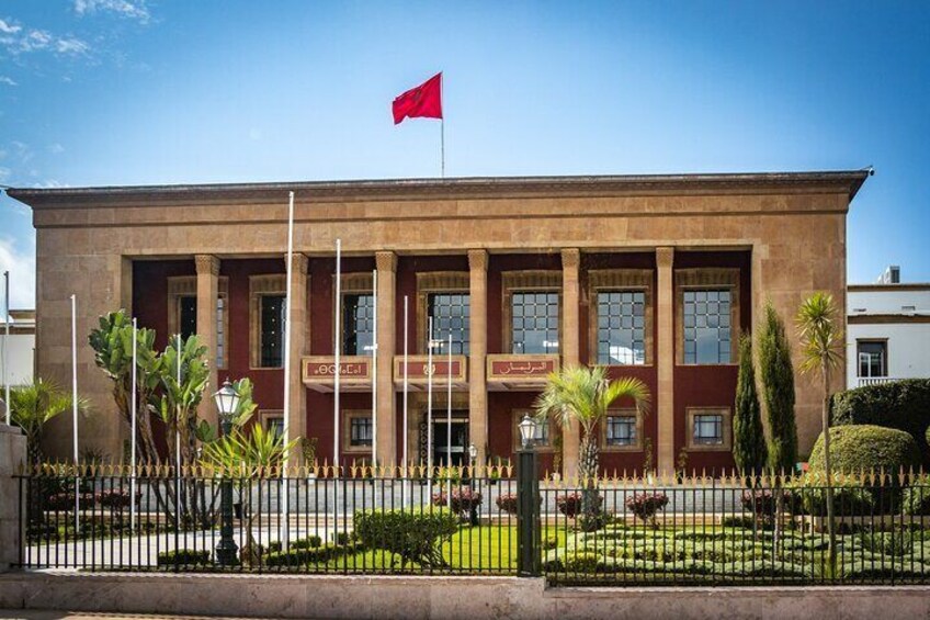 The Parliament building in Rabat, Morocco, a symbol of the nation’s governance and modernity, standing proudly with its distinctive red facade and meticulously maintained gardens.