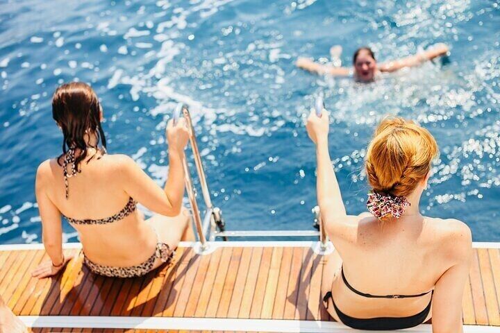 Relaxing on the boat’s deck while friends enjoy a refreshing swim during the Orang Bay day trip with Intours Egypt