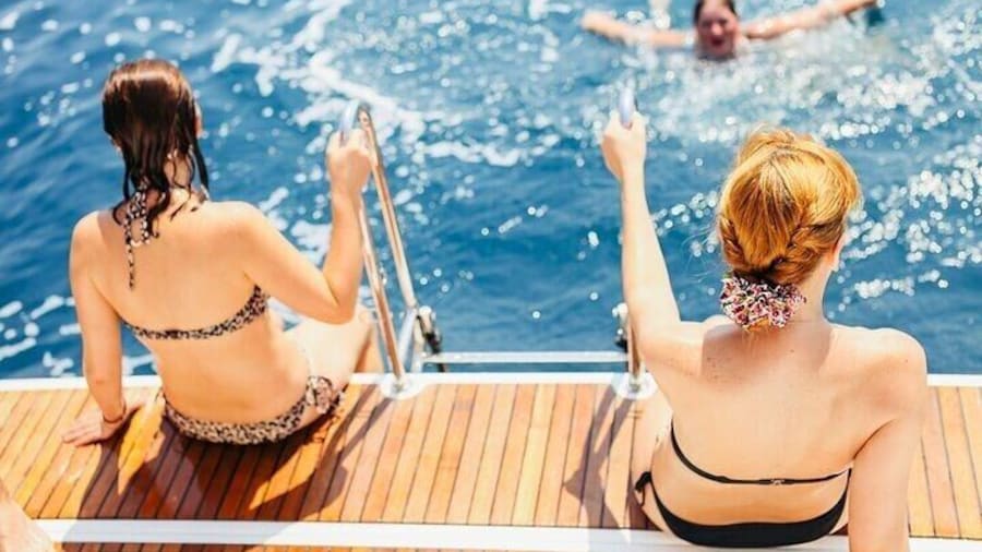 Relaxing on the boat’s deck while friends enjoy a refreshing swim during the Orang Bay day trip with Intours Egypt