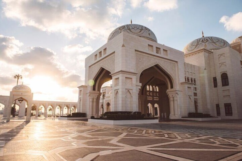Witness the beauty of Qasr Al Watan as the setting sun highlights its intricate details in a warm, golden glow.