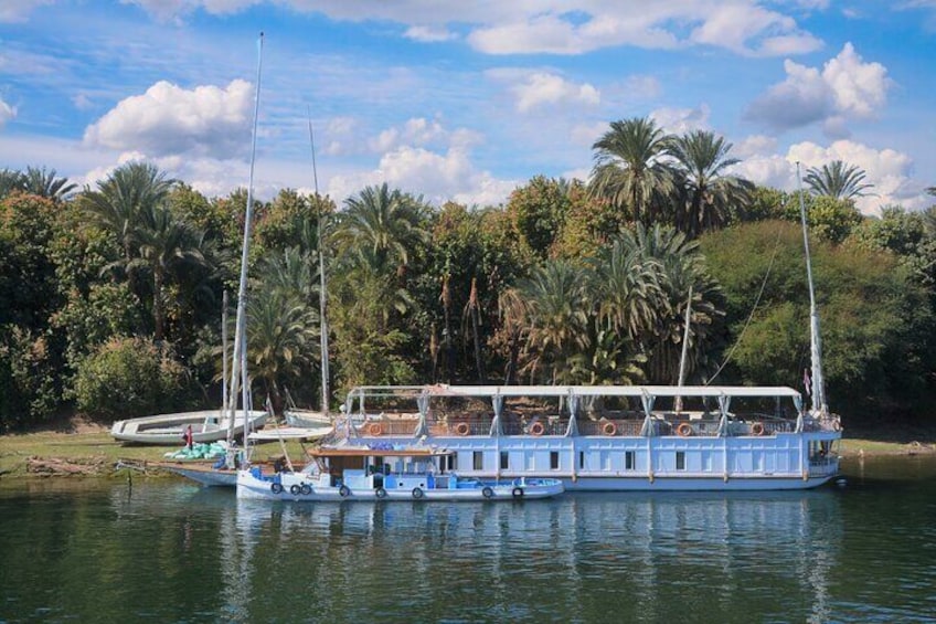  A peaceful scene of a dahabiya gliding down the Nile River, offering a unique and luxurious way to explore Egypt's ancient treasures.