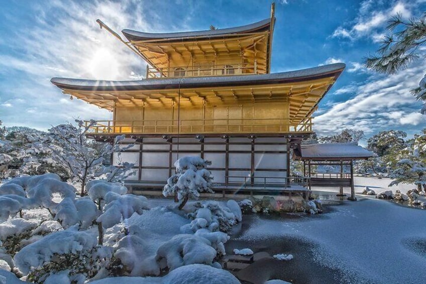 Kinkaku-ji in winter presents a breathtaking scene where the golden pavilion is beautifully contrasted against a backdrop of pristine white snow, creating a magical winter landscape.