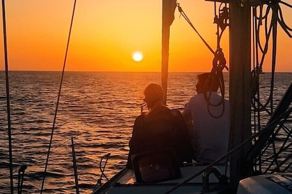 スナックとシャンパンで日没時にイビサ島を航海