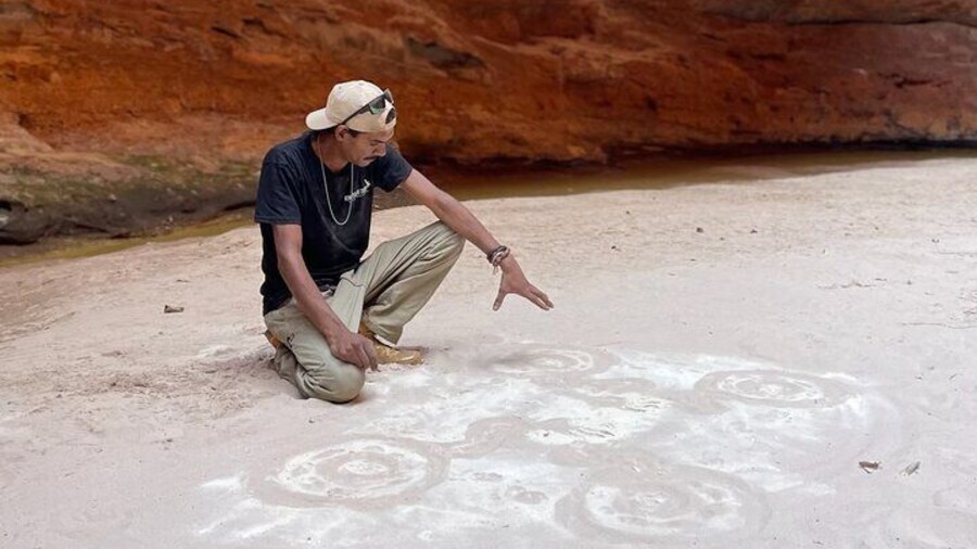 Sand drawing with Kingfisher tours custodian for country Aboriginal guide Kolya in Cathedral Gorge in the Bungle Bungle.