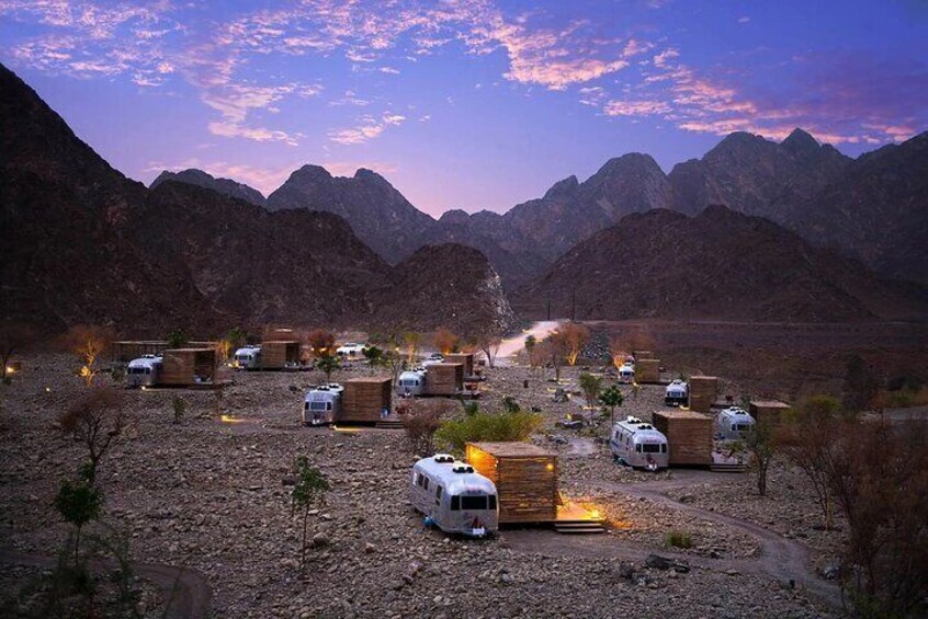 A serene campsite nestled in Hatta's mountainous terrain, offering a peaceful escape under a starry sky.