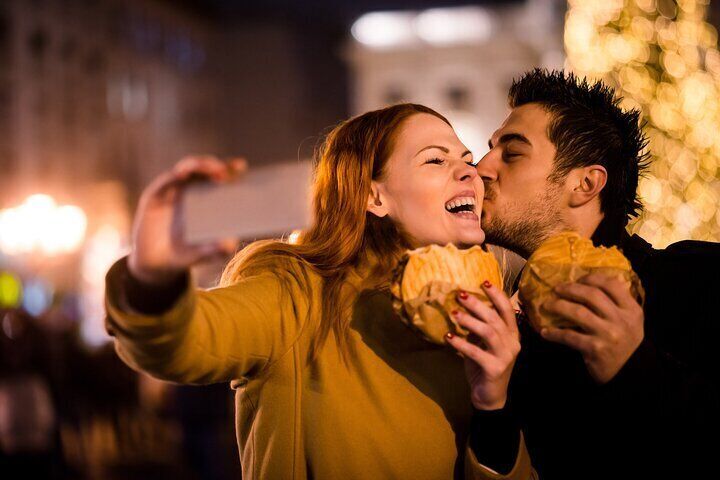 Couple having delicious snacks at the Christmas Market.