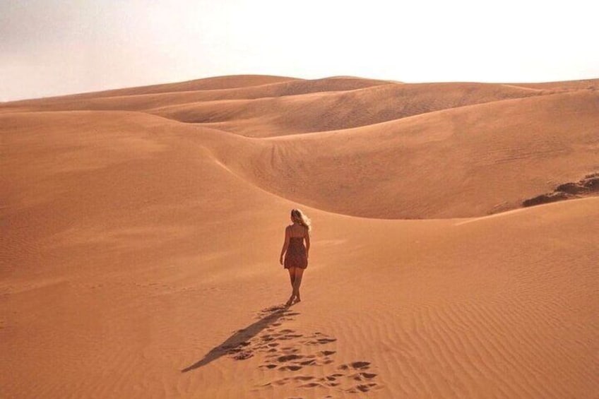 Tourists next to red sand dunes