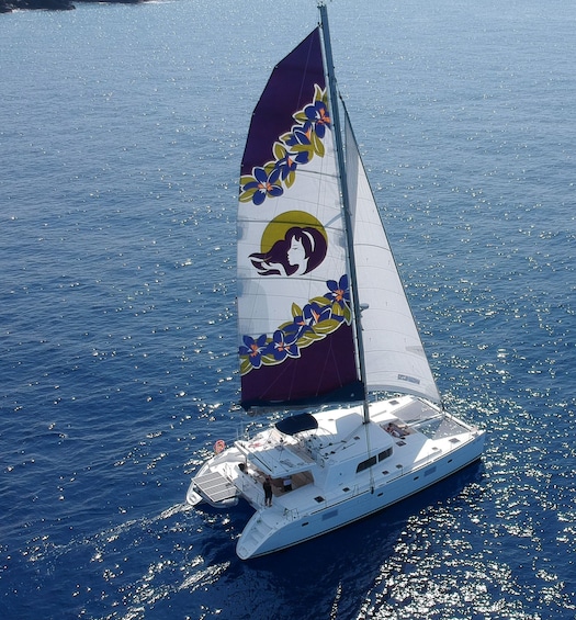 Aerial view of a luxurious yacht sailing along the Kona coast on a sunny day 