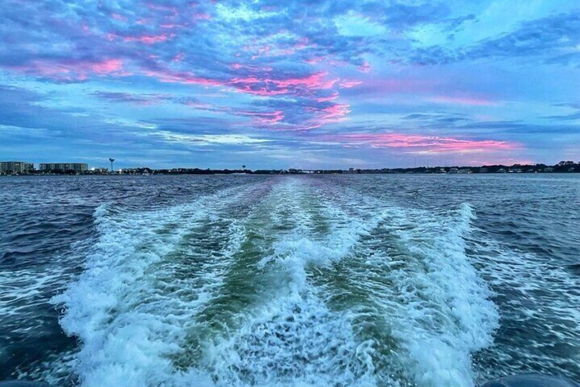 View from SunVenture catamaran of the sun setting over the Destin Harbor. 