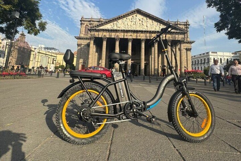 Electric bike with the Teatro Degollado de Guadalajara in the background.