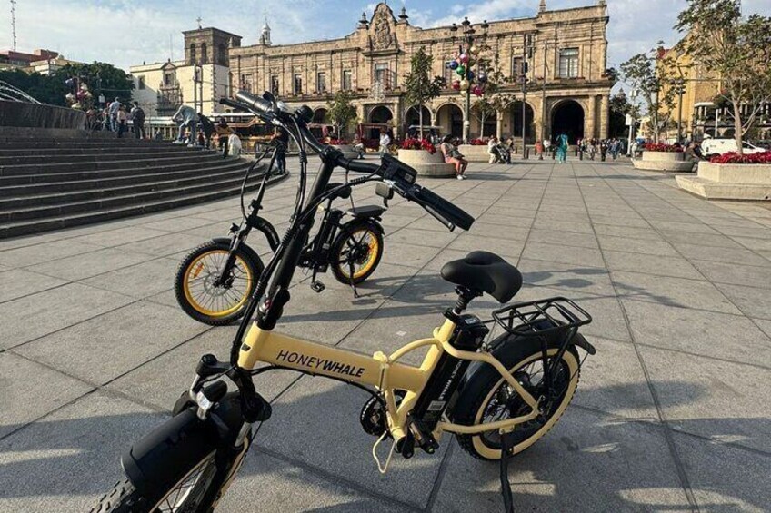 Electric bicycles with the Municipal Palace of Guadalajara in the background.