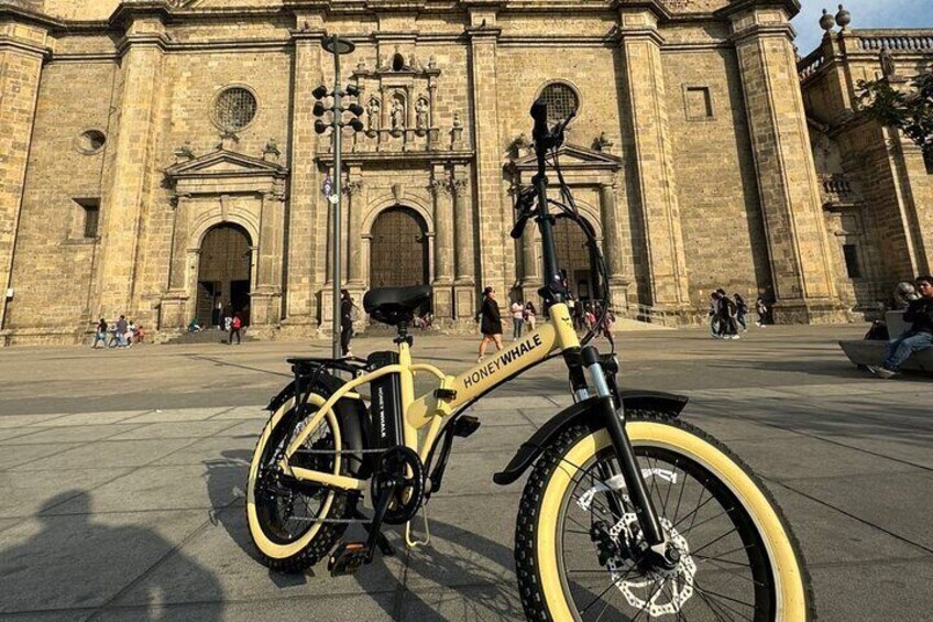 Electric bike with the Basilica Cathedral of the Assumption of Maria Santisima in Guadalajara.