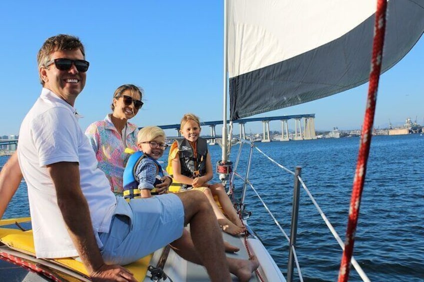 A Family out on the front of the sailboat, enjoying quality time together out on the San Diego Bay
