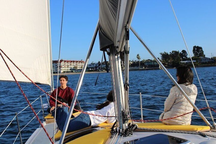 A Family relaxing on a sailboat in the san diego bay on a blue sunny day