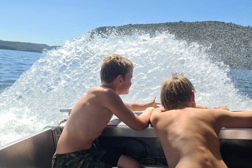 Boys playing with the boat spray on the return journey