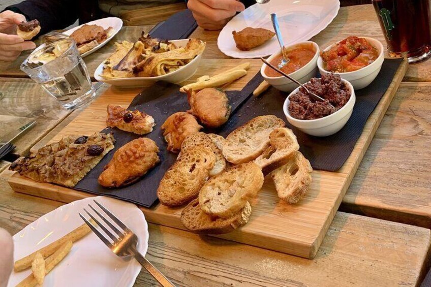 A large wooden board loaded with different dishes and accompaniments Nice.