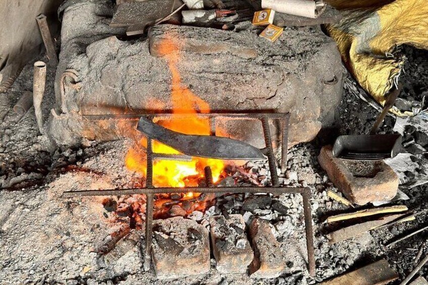 Coil fire burning to metal khukuri knife to take shape 