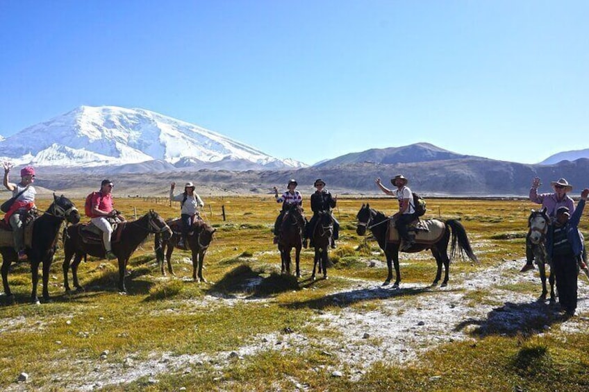 Travelers are riding horse around Karakul lake