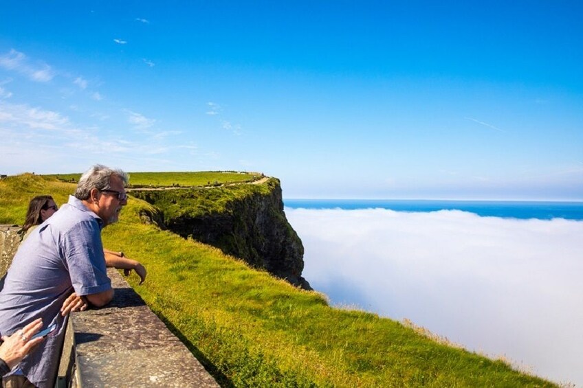 People look over the balcony at the Cliffs of Moher