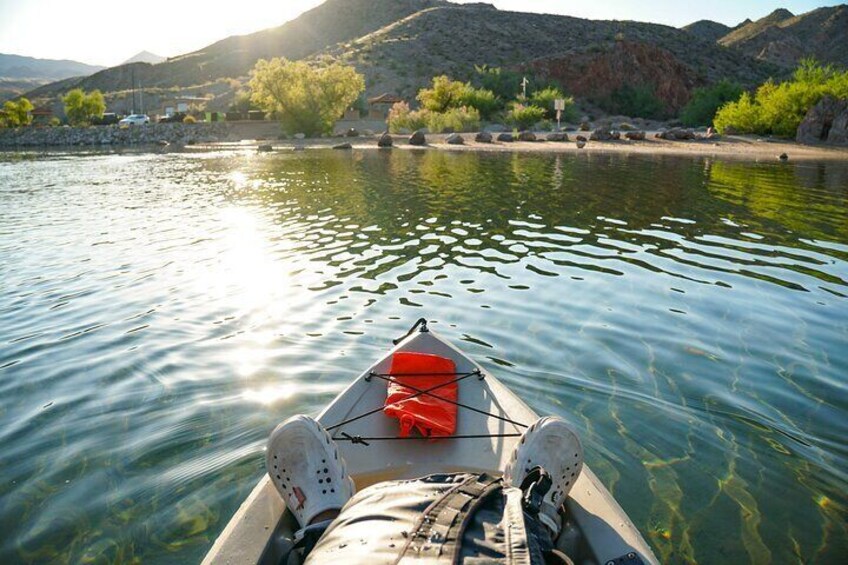 A kayaker watches the sun begin to get low in the sky.