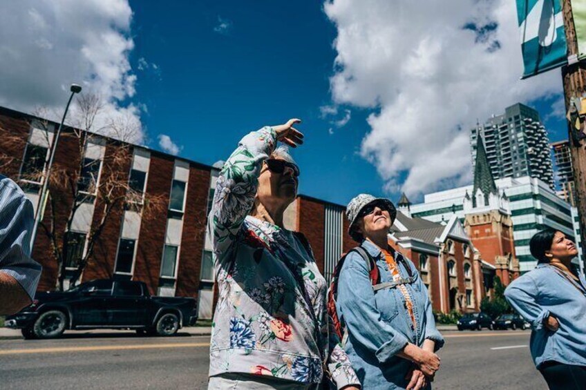Two women look up to view a mural 