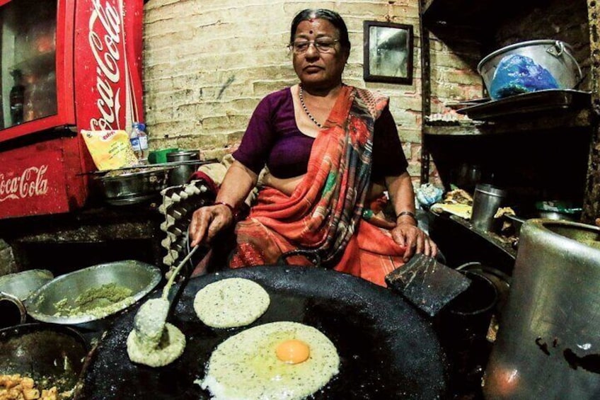 Nepali female lady cooking Bara in Kathmandu Street