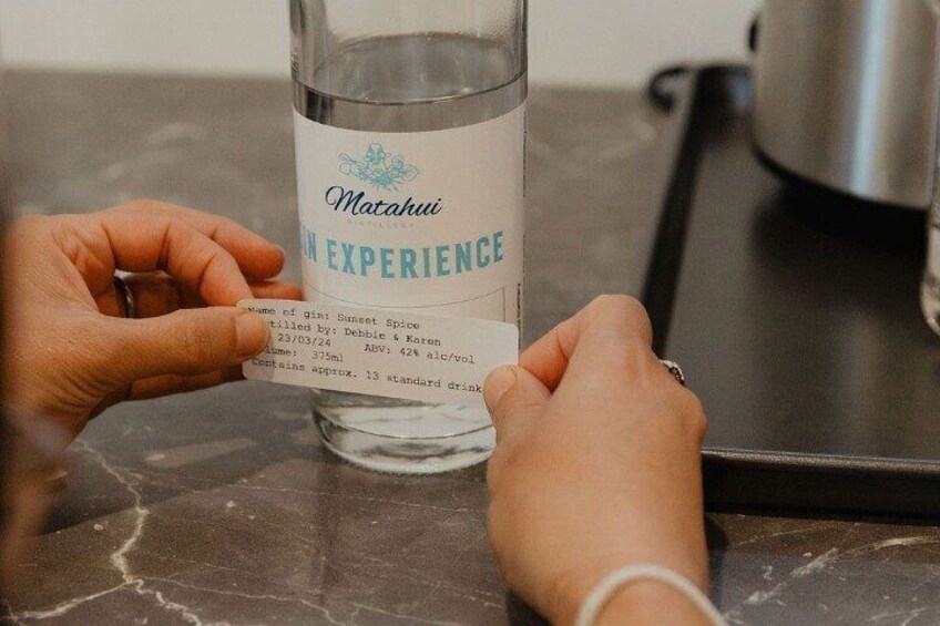 Sticking your label onto your bottle of gin. 