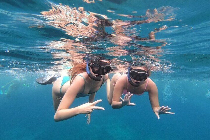 Snorkel with friends off the boat in Comino’s crystal-clear waters, exploring vibrant marine life on an unforgettable private boat tour in Malta