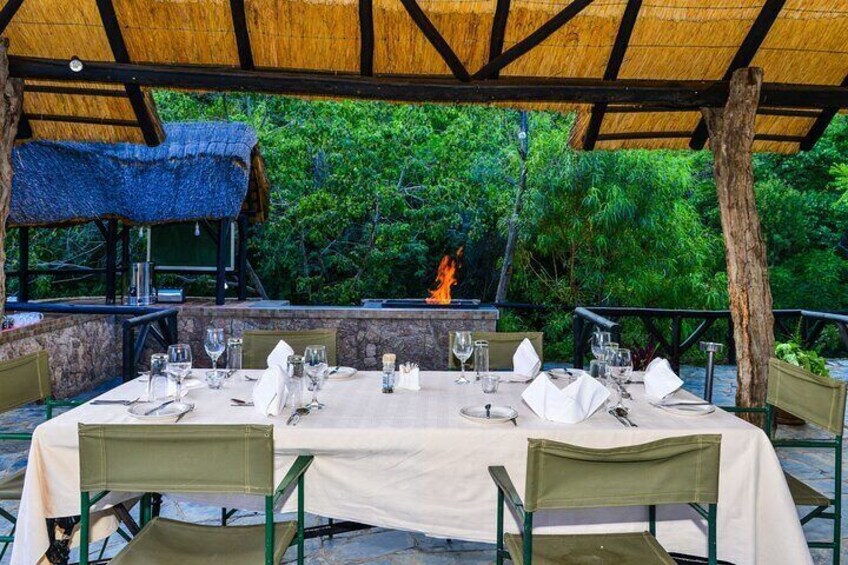 Dine beneath the stars at our enchanting evening setup, where tables elegantly dressed with crisp linens and fine tableware await by the flickering light of our traditional boma fire.