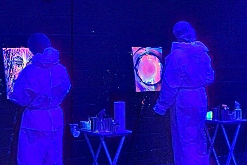 A couple freestyling in the glow-in-the-dark painting main room