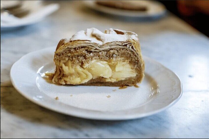 Enjoy a warm, flaky Apfelstrudel, filled with spiced apples—a perfect blend of sweetness and tradition in every bite!