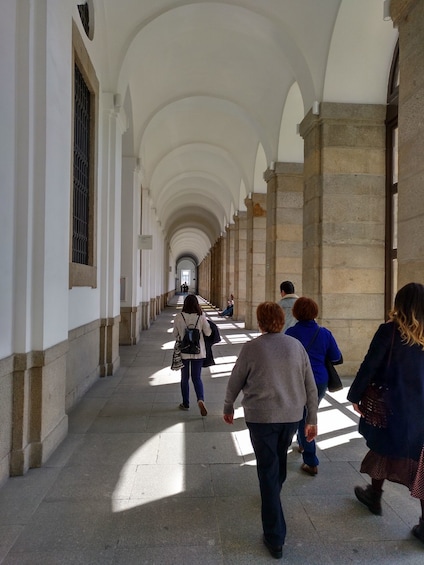 People walk down a museum archway