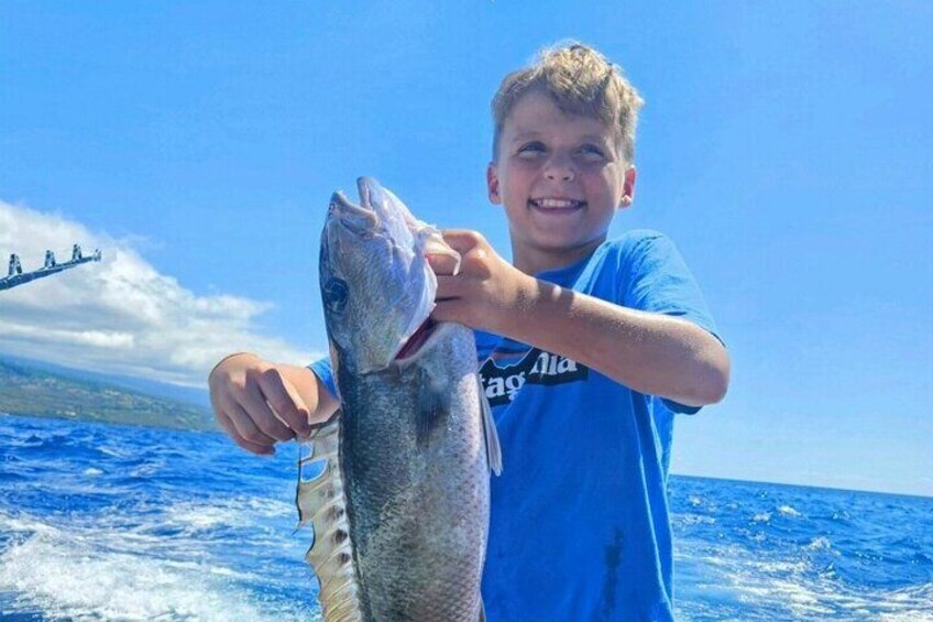 This little anglers holding his catch Aku (Grey Snapper).