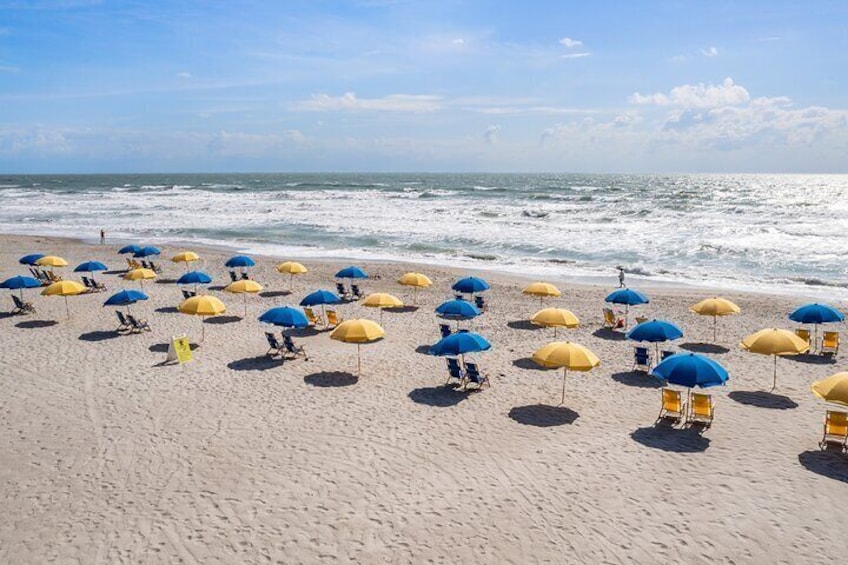 "Experience the magic of our stunning beach location! Settle into our cozy beach chairs under colorful umbrellas, where sun and sea meet for the perfect getaway. Reserve your shore excursion now!