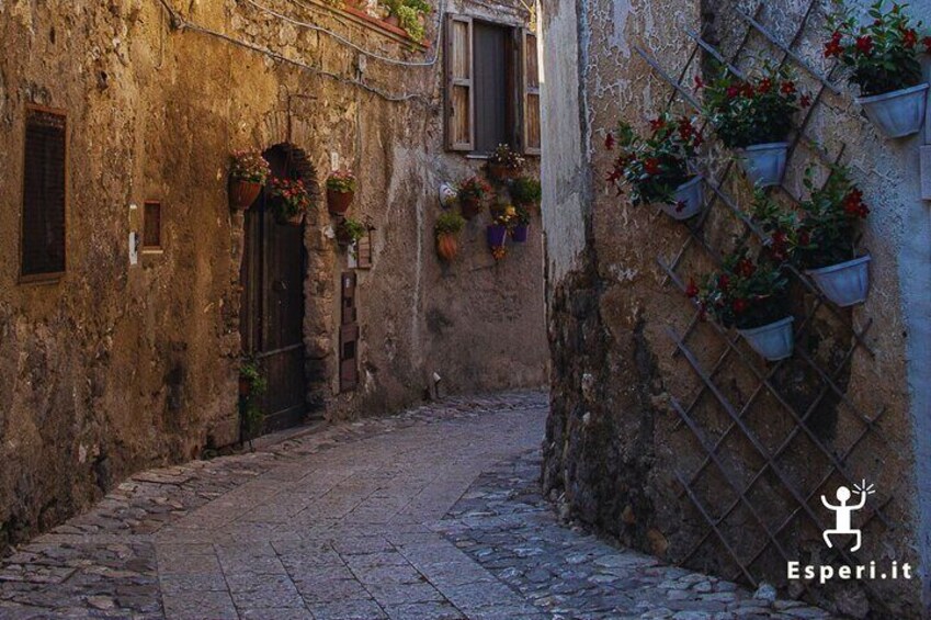 A journey through living stone and colourful flowers in the heart of the village.