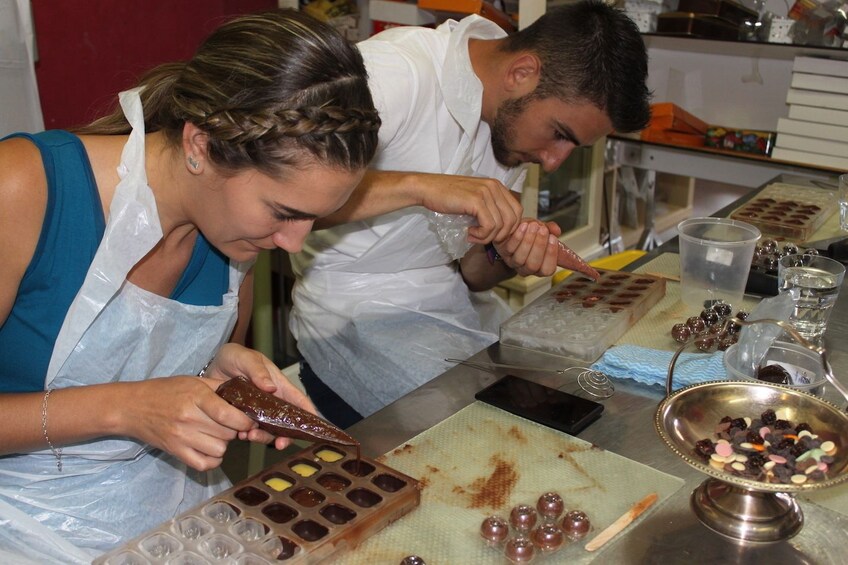 Guests pouring chocolate into a mold on the Chocolate making workshop at Sissys Gourmet Delights in Melbourne 