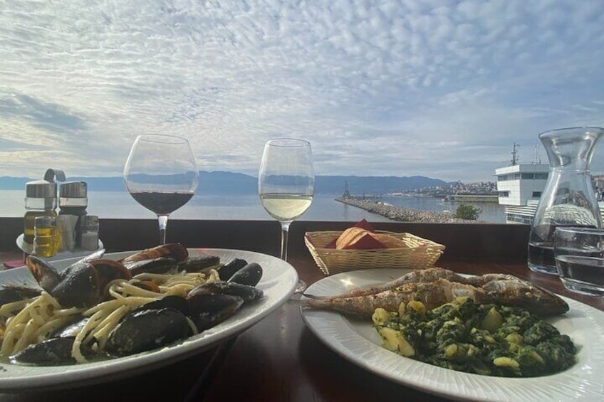 Two typical dishes of Rijeka: seafood pasta and grilled fish with Swiss chard, paired with a glass of local wine – a true taste of the city’s culinary delights!