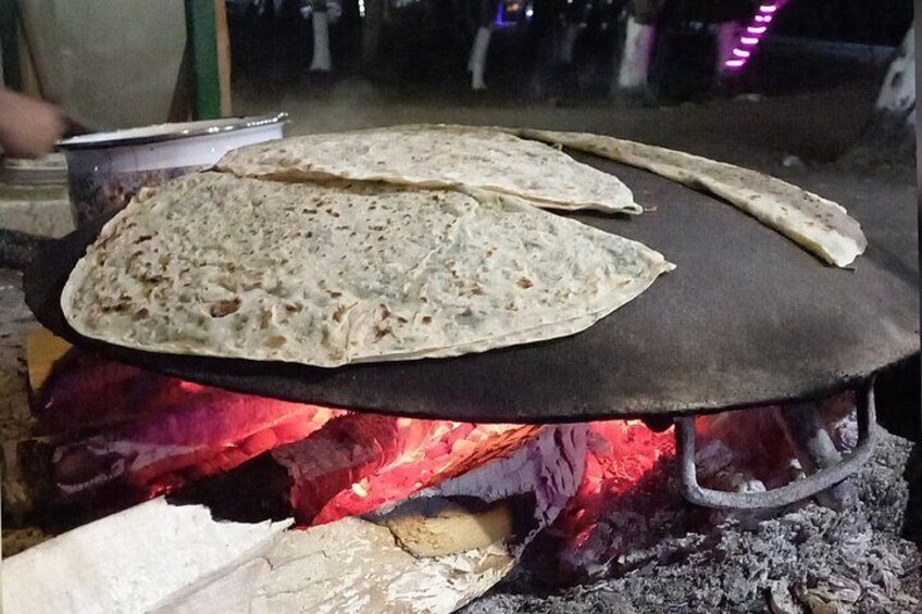 Kutab is a popular Azerbaijani dish made of thin dough filled with greens, meat, or pumpkin, then cooked on a griddle and served with yogurt or sumac.
