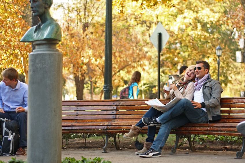 Couple sitting at a bench in a park in 