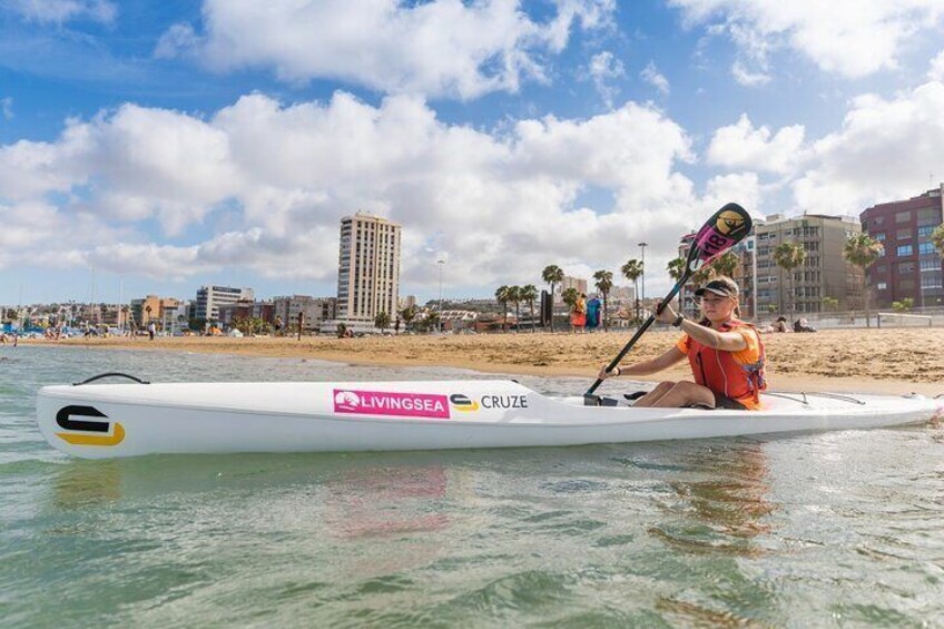 Nazaret starting to paddle in a canoe at Las Alcaravaneras Beach in Las Palmas de Gran Canaria