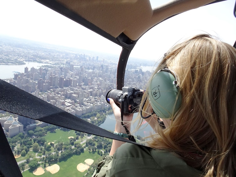 Woman taking photos while aboard a helicopter in NYC 