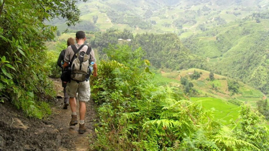 Hikers walk trails of foggy Sapa Valley in Vietnam