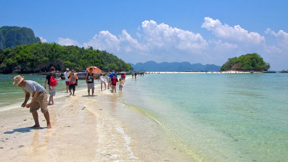 Group walking on a sand bar on an island in Thailand