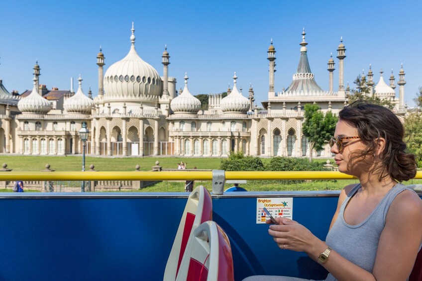 Woman on the double-decker bus in front of the Royal Pavilion in Brighton, England