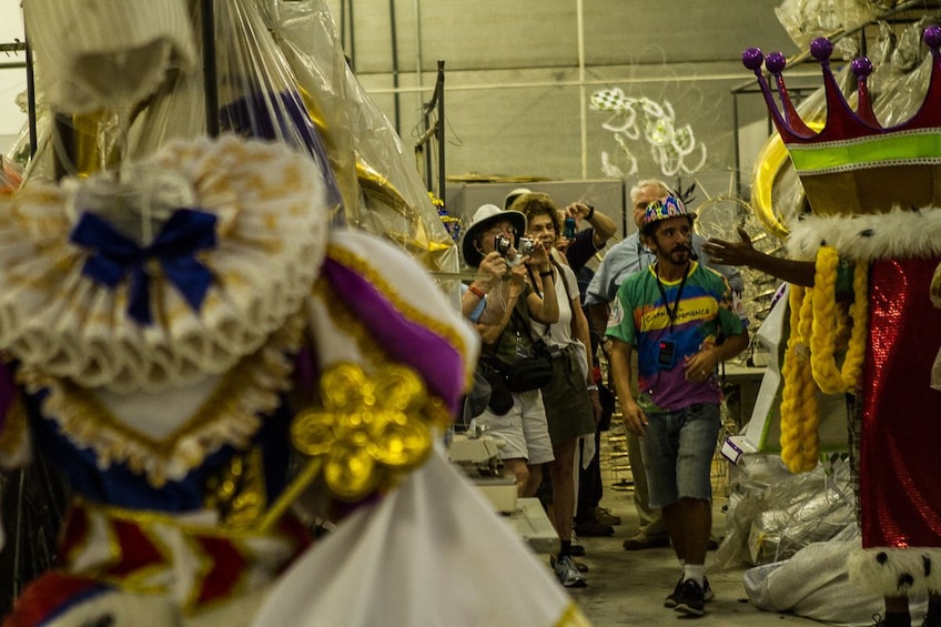 Guide shows tourists rows of Carnaval costumes