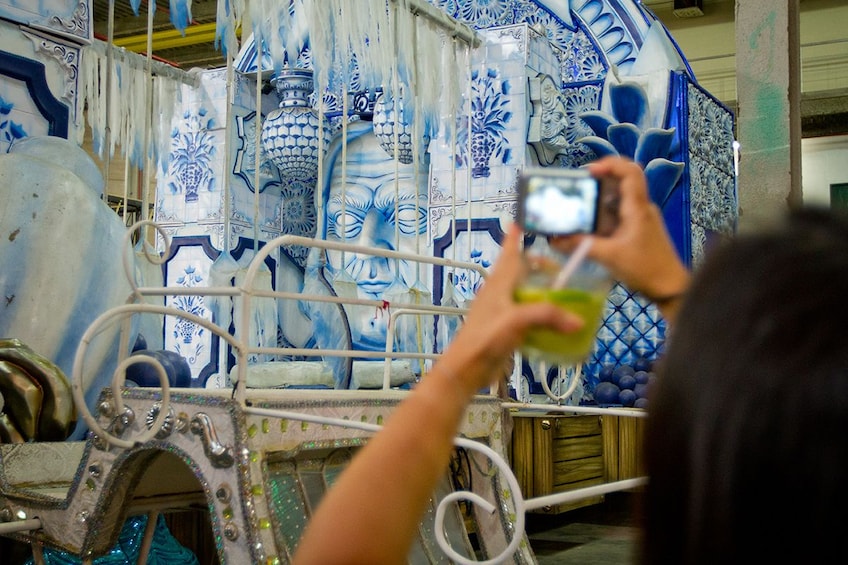 Tourist takes picture of large blue and white float