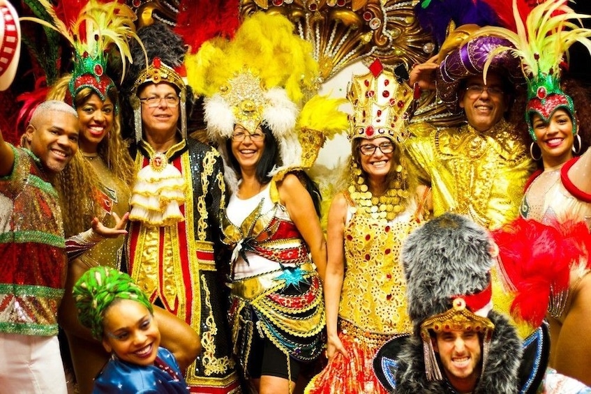 Group of tourists pose in elaborate Carnaval costumes and headpieces 
