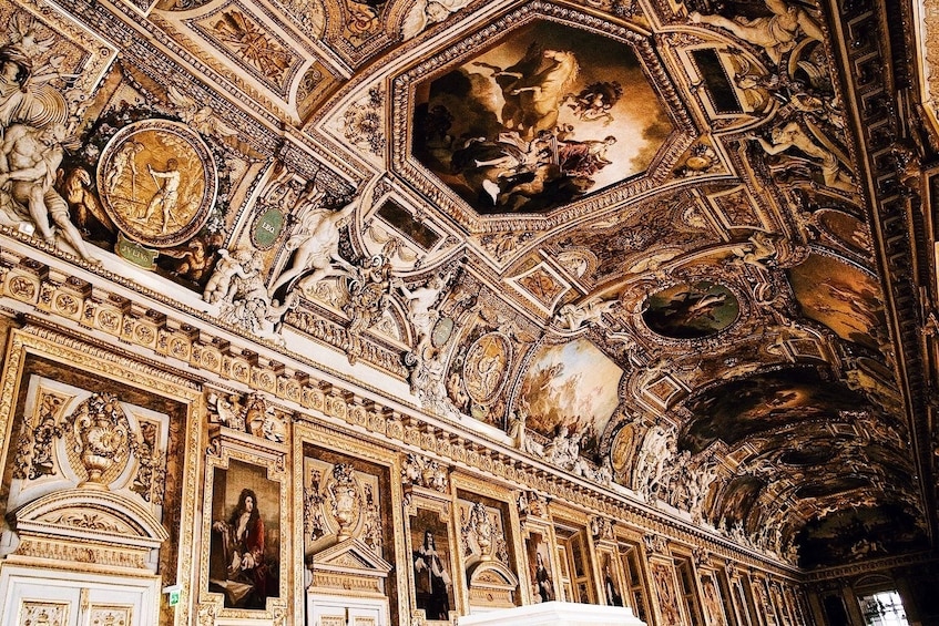 Artwork-covered walls and ceiling at the Louvre Museum in Paris