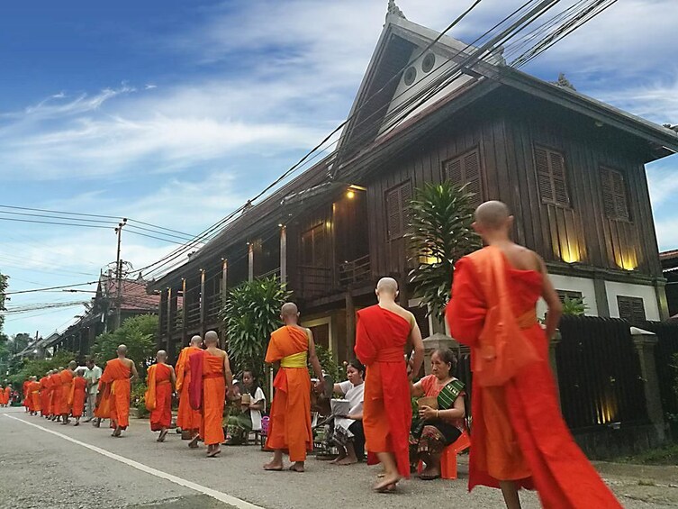 Monks pass temple in Luang Prabang, Laos